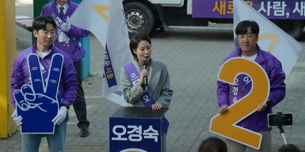 Seoul Mayoral Candidate Oh Kyung Sook slantingly her supportive husband during a wayfarers run